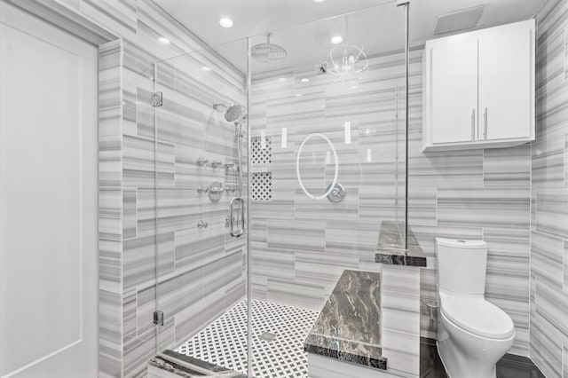 bathroom with tile walls, an enclosed shower, and toilet