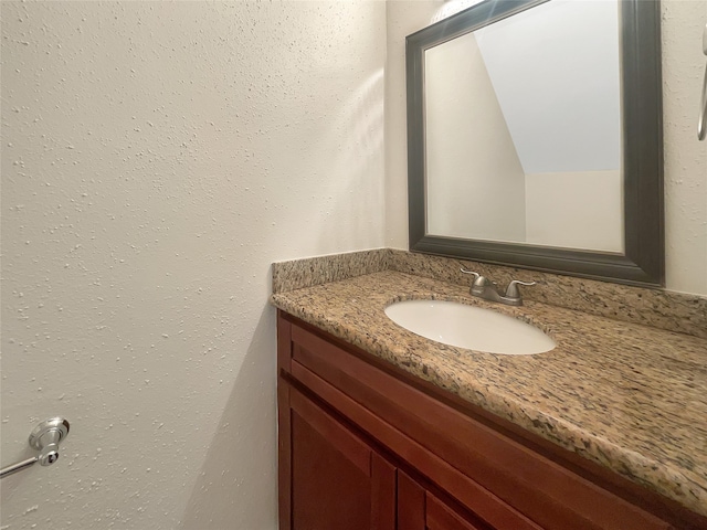 bathroom featuring vanity and lofted ceiling