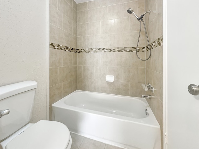 bathroom with tile patterned floors, tiled shower / bath combo, and toilet