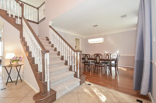 stairs with an AC wall unit, ornamental molding, and hardwood / wood-style floors