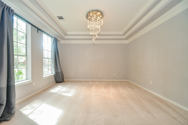 carpeted empty room featuring crown molding, a healthy amount of sunlight, and a raised ceiling