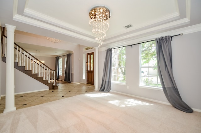 carpeted empty room featuring ornamental molding, a chandelier, and a tray ceiling