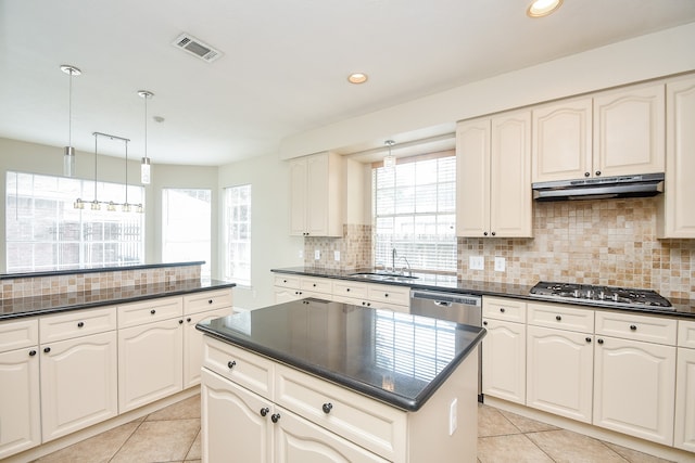 kitchen with sink, stainless steel appliances, decorative light fixtures, and plenty of natural light