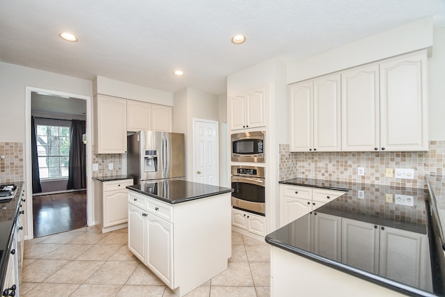 kitchen featuring a kitchen island, white cabinetry, stainless steel appliances, and light tile patterned floors