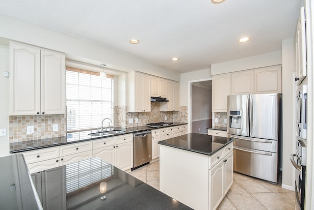 kitchen featuring white cabinets, light tile patterned floors, a kitchen island, sink, and stainless steel appliances