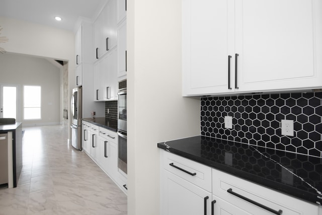 kitchen with white cabinetry, decorative backsplash, and appliances with stainless steel finishes