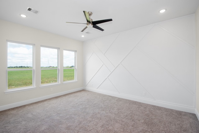 carpeted spare room with ceiling fan