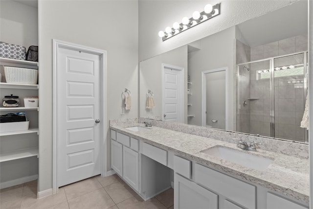 bathroom with tile patterned flooring, a shower with door, and vanity