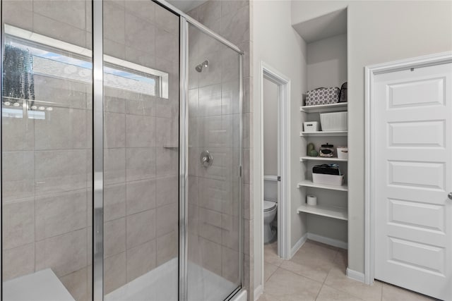 bathroom with a shower with shower door, toilet, and tile patterned floors