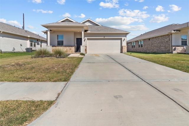 view of front of home with a garage, cooling unit, and a front lawn