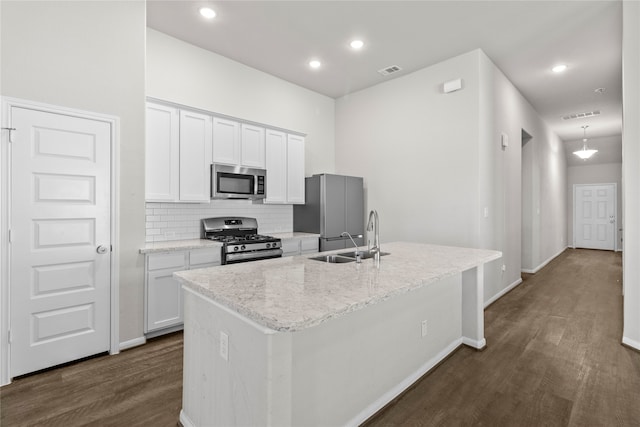 kitchen featuring stainless steel appliances, white cabinetry, a center island with sink, and sink