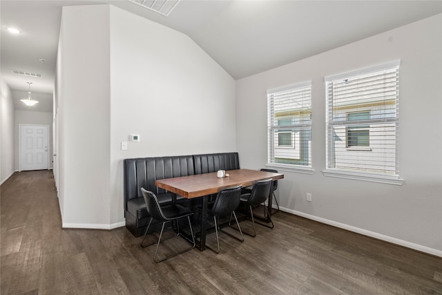 dining room featuring lofted ceiling and dark hardwood / wood-style floors