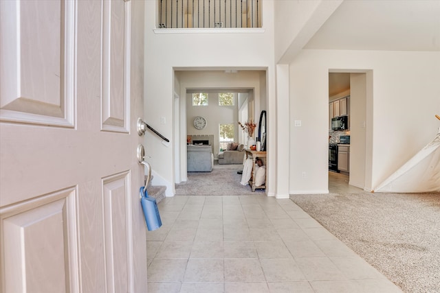 foyer with light carpet and a high ceiling