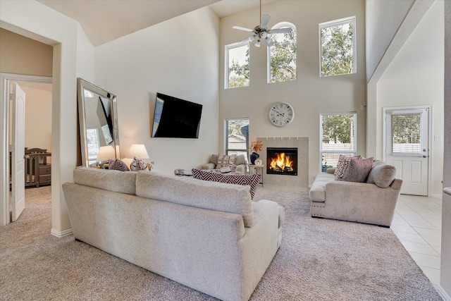 living room with a wealth of natural light, ceiling fan, light colored carpet, and a fireplace