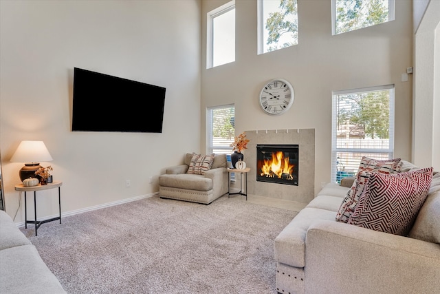 living room with carpet floors, plenty of natural light, and a tiled fireplace