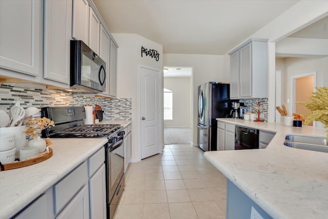 kitchen featuring light tile patterned flooring, appliances with stainless steel finishes, sink, and tasteful backsplash