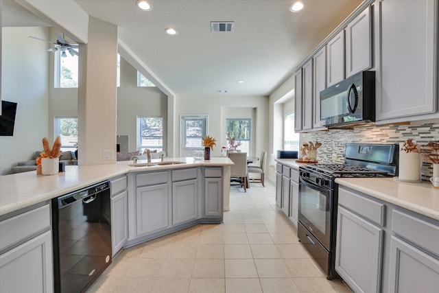 kitchen with ceiling fan, a wealth of natural light, sink, and black appliances