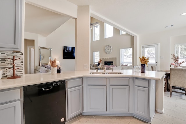 kitchen featuring gray cabinetry, black dishwasher, kitchen peninsula, and sink