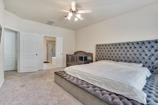 bedroom with ensuite bath, ceiling fan, and light colored carpet