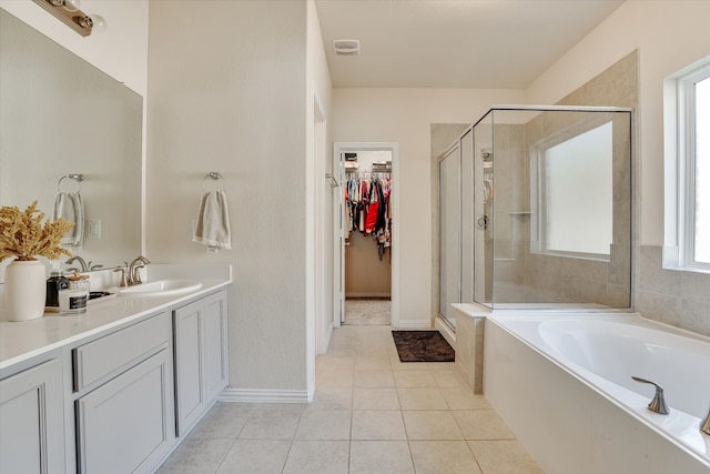 bathroom with tile patterned flooring, independent shower and bath, and vanity