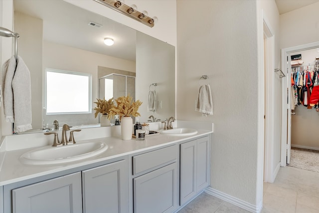 bathroom featuring tile patterned floors, walk in shower, and vanity