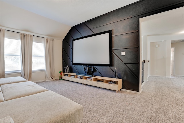 carpeted home theater featuring lofted ceiling