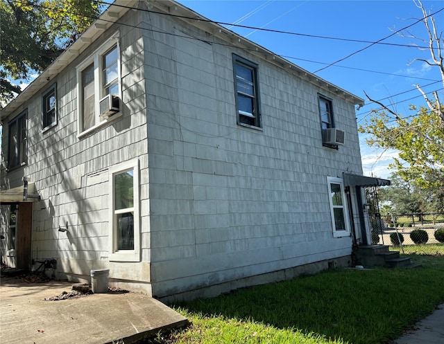 view of property exterior with a lawn and cooling unit