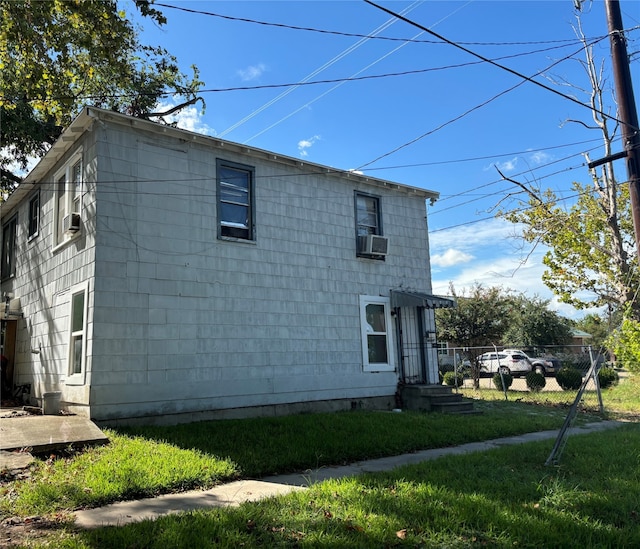 view of side of home with cooling unit and a yard