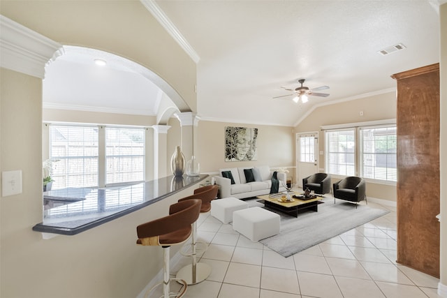 tiled living room featuring crown molding, vaulted ceiling, ceiling fan, and a wealth of natural light