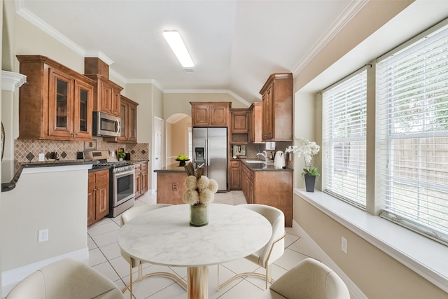 kitchen featuring stainless steel appliances, decorative backsplash, and a healthy amount of sunlight