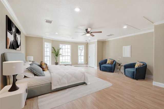 bedroom featuring light wood-type flooring, a textured ceiling, ornamental molding, and ceiling fan