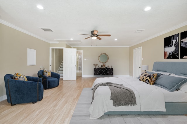 bedroom featuring ornamental molding, light wood-type flooring, ceiling fan, and a textured ceiling