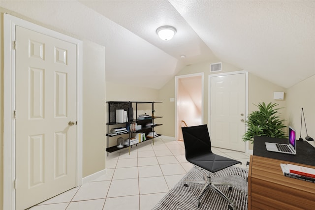 office area with vaulted ceiling, a textured ceiling, and light tile patterned floors