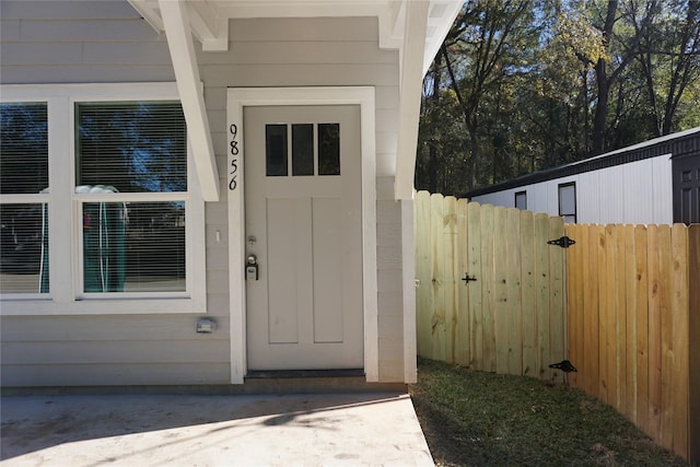 view of exterior entry featuring fence