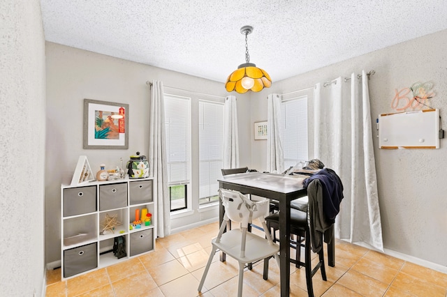 dining area with a textured ceiling and light tile patterned flooring