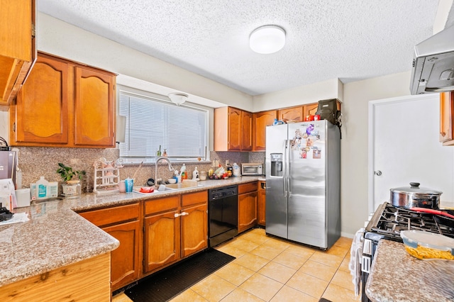 kitchen featuring a textured ceiling, tasteful backsplash, sink, stainless steel appliances, and light tile patterned floors