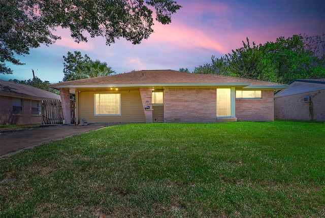 single story home with brick siding and a lawn