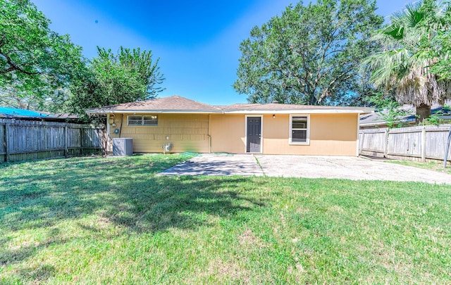 back of house with a patio area, central air condition unit, a fenced backyard, and a yard