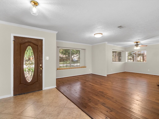 entrance foyer with a textured ceiling, light hardwood / wood-style floors, ceiling fan, and crown molding