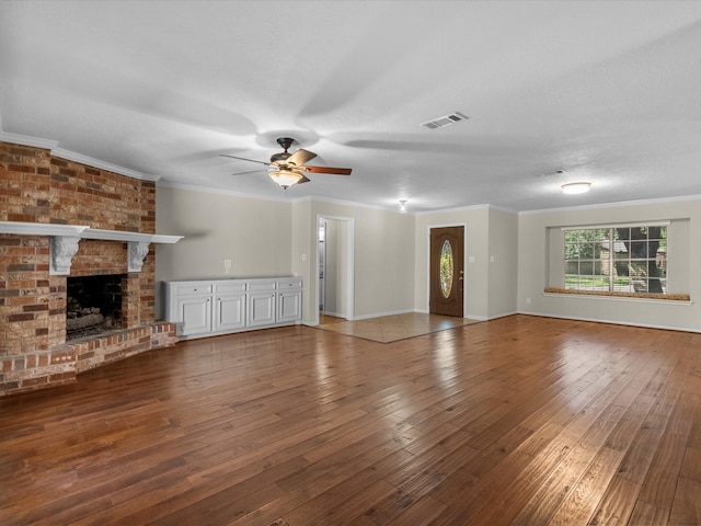 unfurnished living room with crown molding, a fireplace, and hardwood / wood-style floors