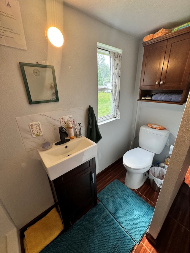 bathroom with toilet, vanity, and hardwood / wood-style floors