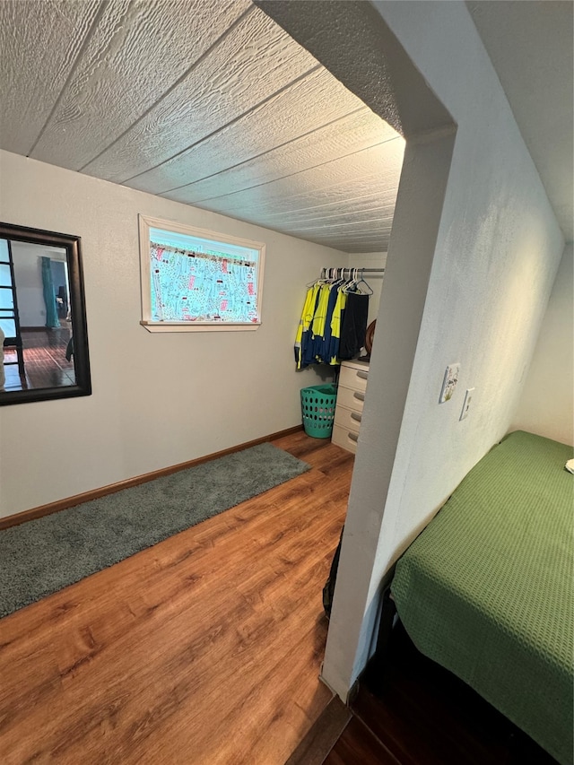 bedroom featuring wood-type flooring, a textured ceiling, and multiple windows