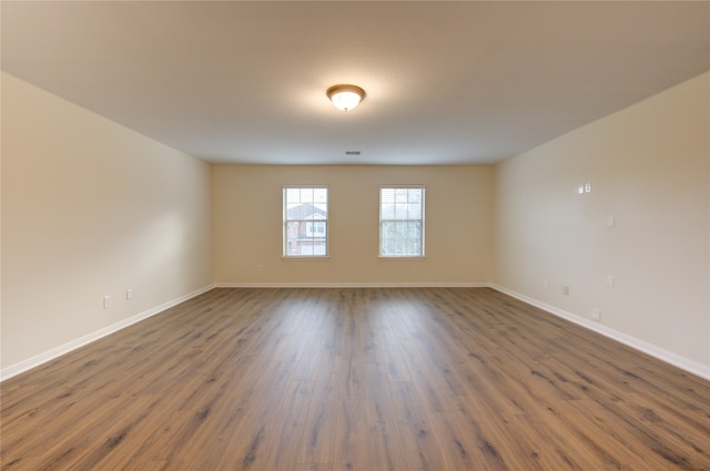 empty room with dark hardwood / wood-style flooring