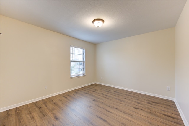 spare room with hardwood / wood-style floors and a textured ceiling