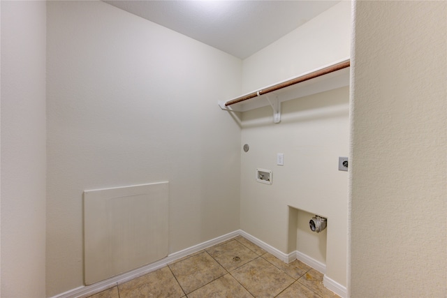 washroom with electric dryer hookup, light tile patterned floors, and washer hookup