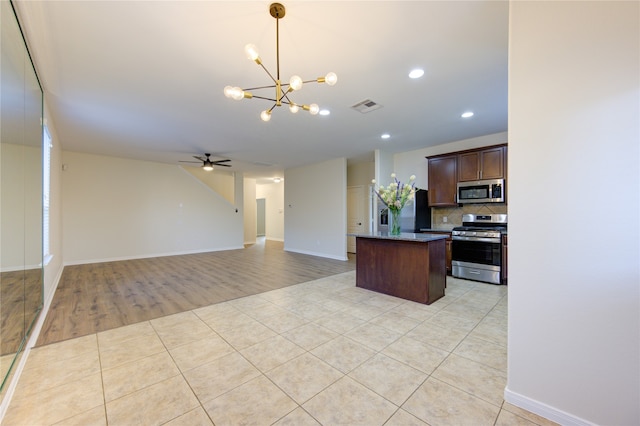 kitchen with stainless steel appliances, backsplash, pendant lighting, light hardwood / wood-style floors, and ceiling fan with notable chandelier