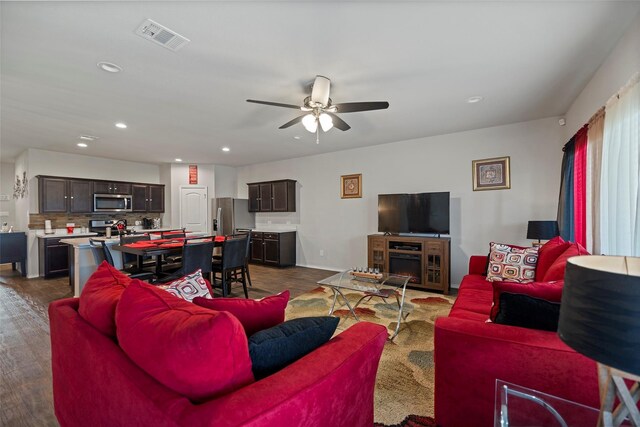 living room featuring ceiling fan and dark hardwood / wood-style floors