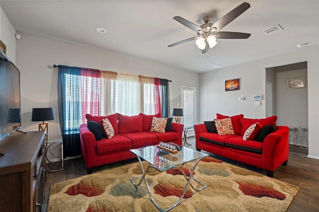 living room with ceiling fan and dark hardwood / wood-style flooring