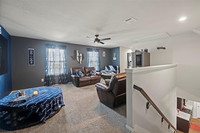 carpeted living room featuring a textured ceiling and ceiling fan