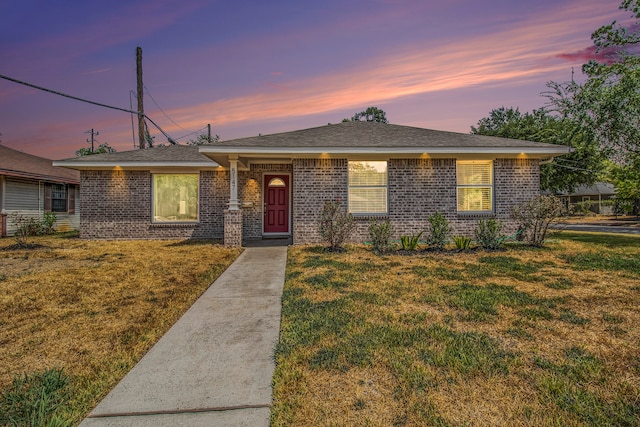 ranch-style home with a lawn